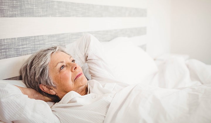Frau grübelt im Bett Frau in den Wechseljahren kann nicht schlafen