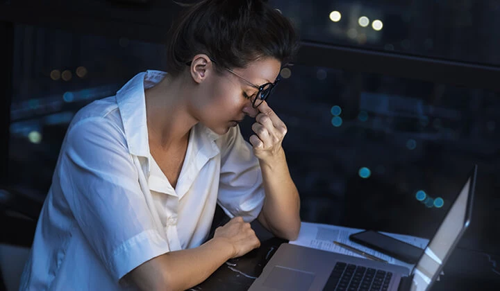 Müde Frau arbeitet Frau sitzt abends müde am Laptop