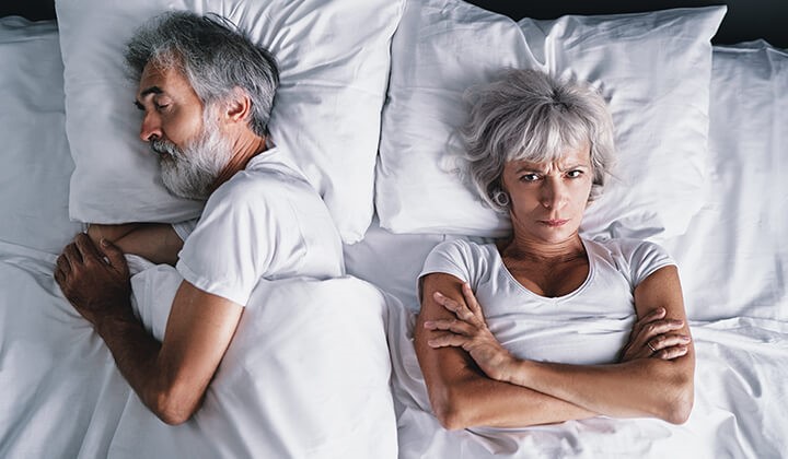 Demenz und Schlafstörungen Unruhiger Schlaf bei Demenz: Eine ältere Frau liegt wach im Bett – häufiges Symptom bei demenziellen Erkrankungen