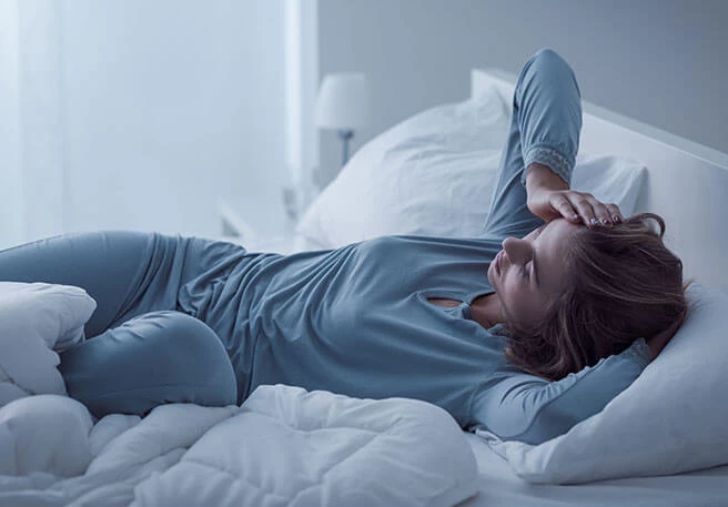 Frau liegt schlaflos im Bett Frau in den Wechseljahren kann nicht schlafen