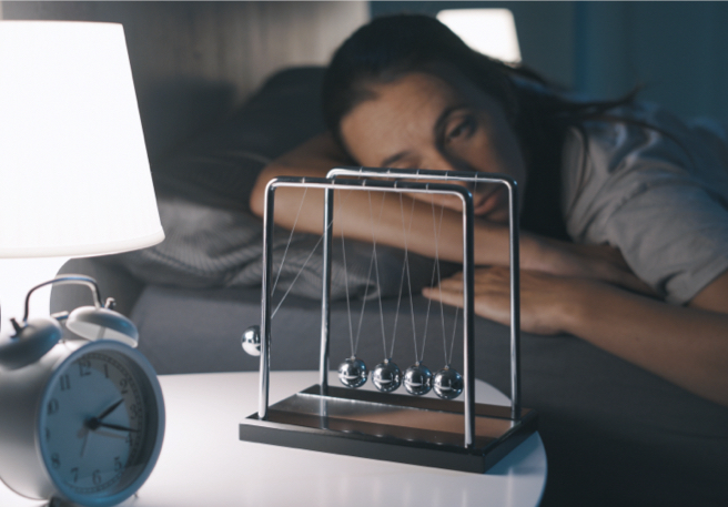 Schlaflose Frau rauft sich die Haare im Bett