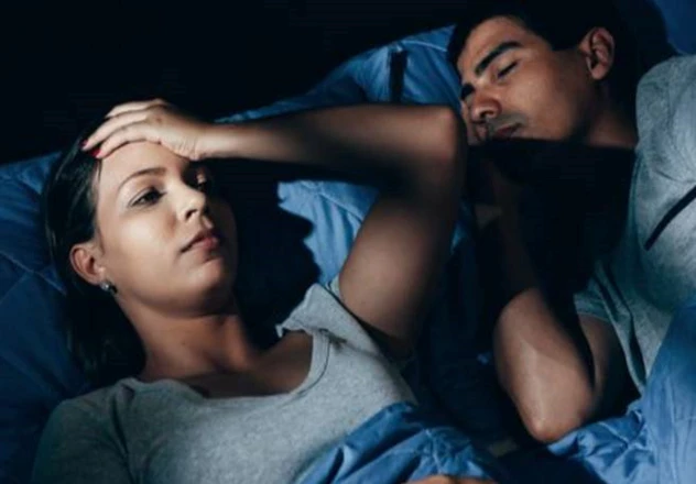 Frau im Bett Frau liegt schlaflos im Bett