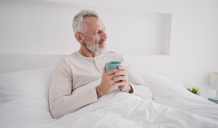 Senior mit Kaffee im Bett Senior mit Kaffee im Bett