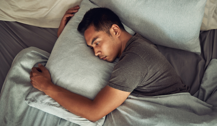 Junger Mann liegt zur Wolfsstunde wach im Bett Junger Mann liegt zur Wolfsstunde wach im Bett